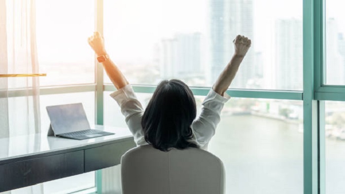 Concept de réussite commerciale avec une femme d'affaires heureuse se relaxant dans un bureau - société de domiciliation entreprise Madagascar - Buro Services