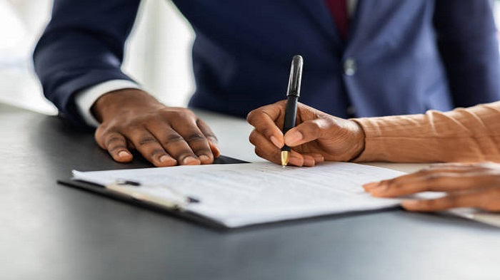 un homme d'affaire en train de faire signer un contrat par un client - voyager à Madagascar - Buro Services