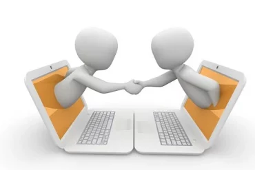 Deux personnes qui se sert la main à travers deux écrans pour passer un accord - contrat d'externalisation - Buro Services
