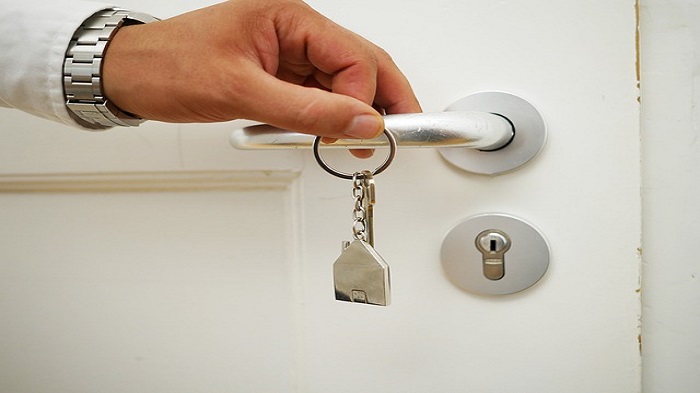 une main tenant une clé sur une poignée - domicilier une société - Buro Services