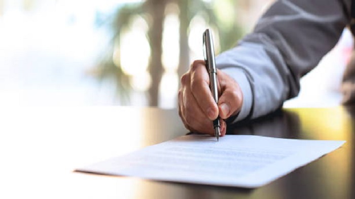 un homme signant un contrat - recherche location de bureau - Buro Services