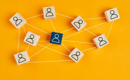 Blocs de bois avec icône de personnes sur fond jaune - salarié en portage salarial - Buro Services