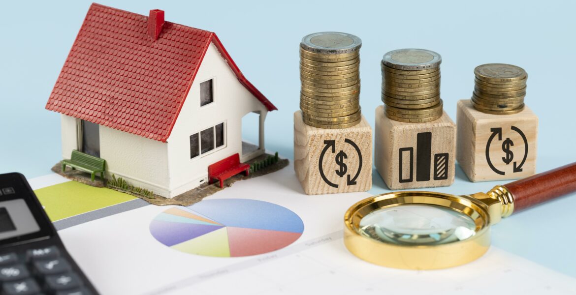 une maquette de maisons et des piles d'argent sur une table - coût réel d'une domiciliation d'entreprise - Buro Services