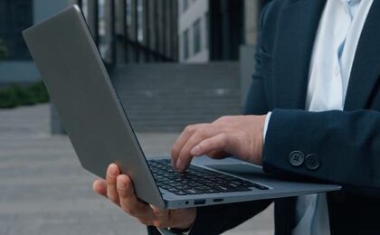 un homme d'affaires anonyme tapant sur un ordinateur - créer une société à Madagascar - Buro Services