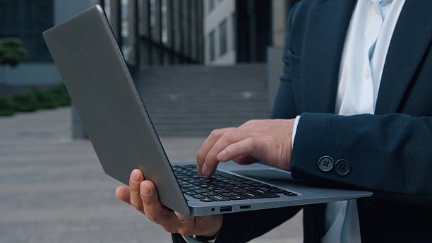 un homme d'affaires anonyme tapant sur un ordinateur - créer une société à Madagascar - Buro Services