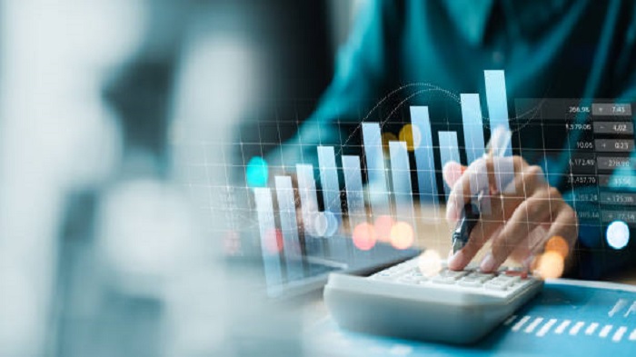 Une femme d'affaires utilise un ordinateur portable et une calculatrice pour analyser la croissance de l'entreprise - fiscalité outsourcing Madagascar - Buro Services