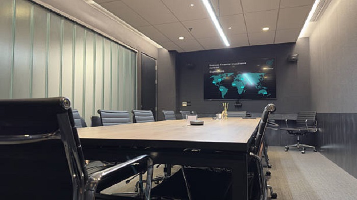 Une salle de conférence moderne avec un grand écran affichant des données et une carte du monde - société de domiciliation - Buro Services
