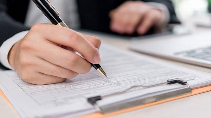 un gros plan sur des mains travaillant sur un contrat - société de domiciliation - Buro Services