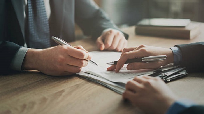 deux hommes d'affaires signant un contrat - domiciliation d'une entreprise - Buro Services